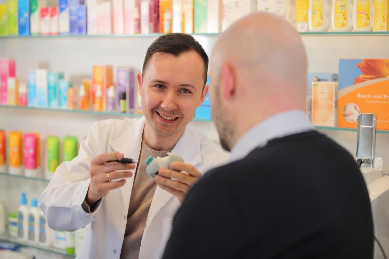 Post "Wir brauchen die Preisbindung bei verschreibungspflichtigen Medikamenten!". Ein Apotheker erklärt einem Kunden das Medikamentenprodukt.