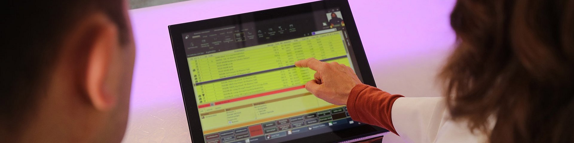 Ein Apotheker und eine Apothekerin gehen gemeinsam eine Liste auf einem Display durch. Die Liste beinhaltet einige Medikamente in verschiedenen Dosierungen.